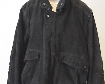May include: A black suede bomber jacket with a zipper closure and a stand-up collar. The jacket has two large pockets on the front and ribbed cuffs and hem.