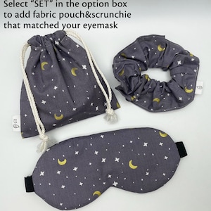 Puede incluir: Un conjunto de antifaz, coletero y bolsa con cord&oacute;n grises. La tela presenta un estampado de lunas doradas y estrellas blancas. El antifaz tiene una banda el&aacute;stica negra. El texto de la imagen dice: "Select SET in the option box to add fabric pouch&scrunchie that matched your eyemask."