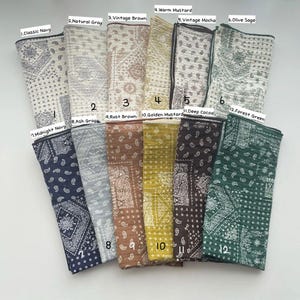 Puede incluir: Doce cuadrados de tela doblados con patrones de cachemira y geom&eacute;tricos, numerados del 1 al 12 con nombres de colores que incluyen Classic Navy, Natural Gray, Vintage Brown, Warm Mustard, Vintage Mocha, Olive Sage, Midnight Navy, Ash Gray, Rust Brown, Golden Mustard, Deep Cocoa y Forest Green.