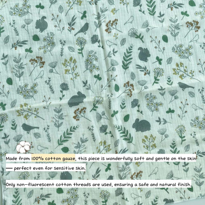 May include: A white cotton gauze fabric featuring a repeating pattern of green and brown botanical illustrations, including various leaves, flowers, birds, squirrels, and rabbits. The fabric has a textured, crinkled appearance throughout the surface.