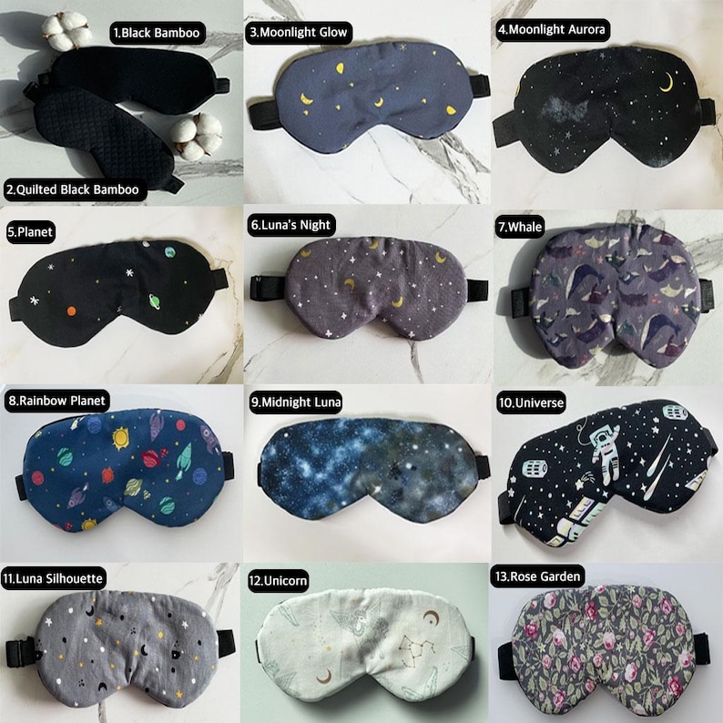 Op de afbeelding: Dertien verschillende slaapmaskers met verschillende patronen en kleuren. De patronen omvatten zwarte bamboe, gestikte zwarte bamboe, maanlicht gloed, maanlicht aurora, planeet, luna's nacht, walvis, regenboog planeet, middernacht luna, universum, luna silhouet, eenhoorn en rozentuin.