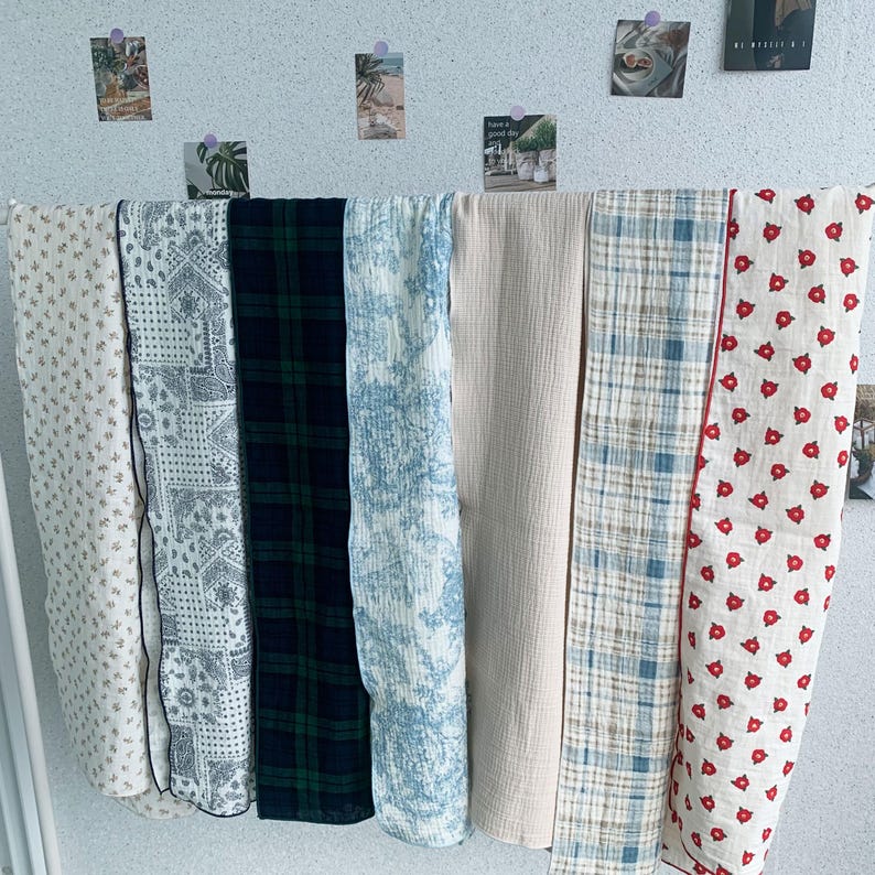 Peut inclure: Sept &eacute;chantillons de tissu rectangulaires pr&eacute;sent&eacute;s c&ocirc;te &agrave; c&ocirc;te. Les motifs incluent des petites fleurs beiges, un cachemire noir et blanc, un tartan vert fonc&eacute; et bleu marine, une toile bleue et blanche, un cr&egrave;me uni, un tartan bleu et blanc.
