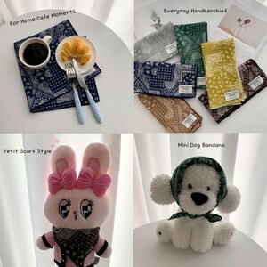 May include: A collection of square fabric handkerchiefs featuring various paisley patterns in colors including navy, green, yellow, brown, and gray. The set includes a plush pink rabbit and a white plush dog wearing a green paisley bandana.