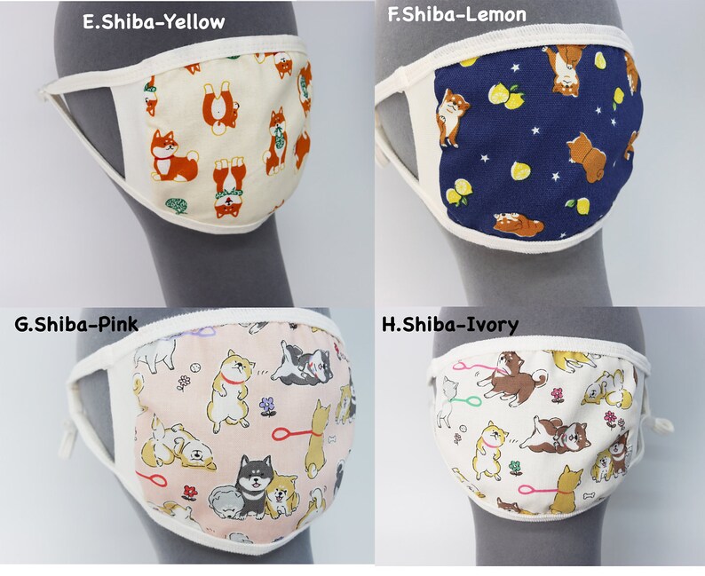 Op de afbeelding: Vier stoffen gezichtsmaskers met Shiba Inu hondenpatronen. E.Shiba-Yellow heeft een cr&egrave;mekleurige achtergrond, F.Shiba-Lemon een donkerblauwe achtergrond met citroenen, G.Shiba-Pink een lichtroze achtergrond en H.Shiba-Ivory een ivoorkleurige achtergrond.