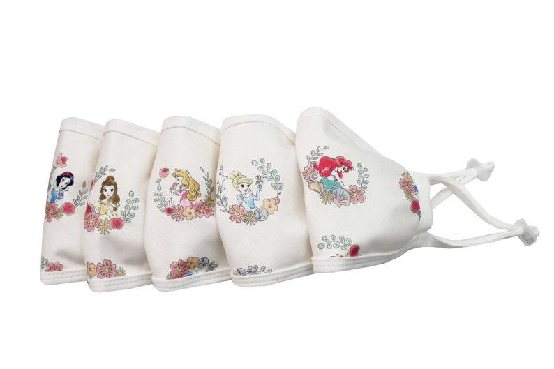 May include: Set of five white cotton face masks featuring different Disney princesses. Each mask has a floral design and a different princess, including Snow White, Belle, Cinderella, Ariel, and Rapunzel.