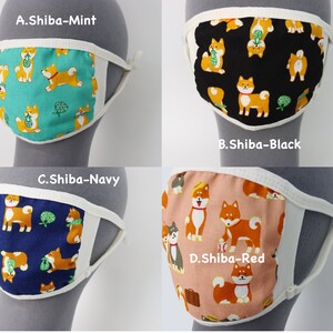 Op de afbeelding: Vier stoffen mondkapjes met Shiba Inu-hondenpatronen in mintgroen, zwart, marineblauw en rood. Elk masker heeft een witte rand en elastische oorlussen. De tekstlabels A.Shiba-Mint, B.Shiba-Black, C.Shiba-Navy en D.Shiba-Red zijn zichtbaar.