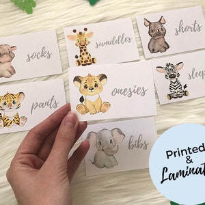 May include: Set of 8 baby clothes labels with cute animal illustrations. The labels include: socks, pants, onesies, bibs, swaddles, sleepers, shorts. The labels are printed and laminated.