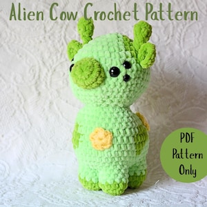 May include: A handmade crocheted alien cow toy in light and dark green, with yellow patches. It has large black eyes and small, rounded horns. The text "Alien Cow Crochet Pattern" is at the top, and a green circle with "PDF Pattern Only" is on the right.