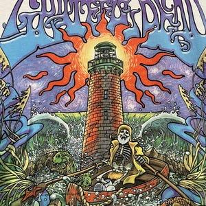May include: White t-shirt featuring a colorful graphic design. The design includes a lighthouse, a skeleton in a boat, and the words "Grateful Dead" in a swirling font. The artwork is vibrant with blues, oranges, and greens.