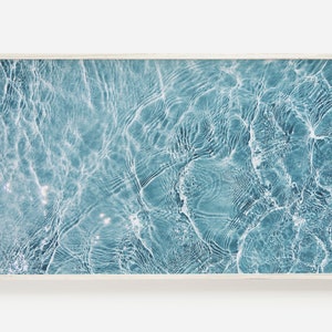 May include: A close-up photo of rippling blue water with light reflecting off the surface.