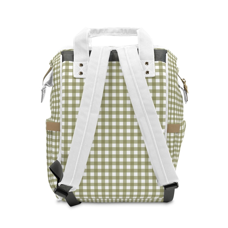 K&ouml;nnte beinhalten: Ein gr&uuml;ner und wei&szlig;er karierter Rucksack mit wei&szlig;en verstellbaren Tr&auml;gern und schwarzen Schnallen.