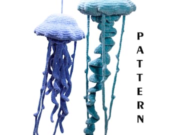 May include: Two handmade crochet jellyfish in shades of blue. The jellyfish have a rounded top and long, flowing tentacles. The word "PATTERN" is printed vertically in black on the right side of the image.