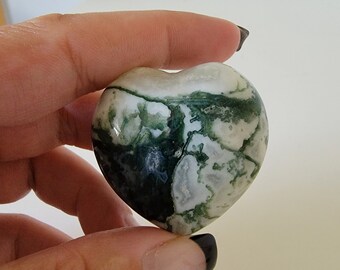 May include: A heart-shaped green and white agate stone with a swirling pattern.