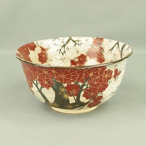 May include: A white ceramic bowl with a red and gold floral design. The bowl features a stylised tree with red flowers and gold accents. The bowl is perfect for serving rice or other Asian dishes.