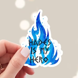May include: A blue watercolor flame sticker with the text "Hades is my hero" in black.