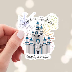 May include: A sticker featuring a white castle with blue accents and fireworks. The text "reach out and find your happily ever after" is below the castle.