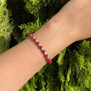 Armband met turkoois en koraalkralen: verstelbare boho-stijl, rode en blauwe armcandy