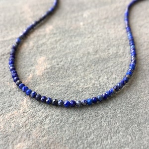 Lapis lazuli beaded necklace with 3mm faceted navy blue beads. The necklace has gold clasp and extender chain.