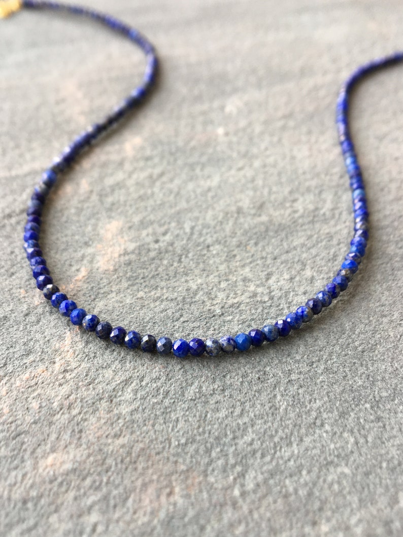 Lapis lazuli beaded necklace with 3mm faceted navy blue beads. The necklace has gold clasp and extender chain.