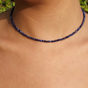 Lapis lazuli beaded necklace with 3mm faceted navy blue beads. The beads are shining in the light and it has the fitof a chokerfor the model.