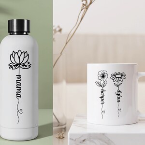 May include: White water bottle with a black lotus flower and the word "mama" written vertically.  White mug with two black flowers and the names "dylan" and "harper" written vertically.