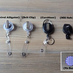 Puede incluir: Se muestran cuatro estilos diferentes de carretes para insignias sobre una superficie de madera. Los estilos incluyen un clip de cocodrilo giratorio, un clip para cintur&oacute;n, un mosquet&oacute;n y un carrete seguro para resonancia magn&eacute;tica. Tambi&eacute;n se muestra una peque&ntilde;a insignia con borde festoneado con rayas azules y rosas, etiquetada como "(No Badge)".