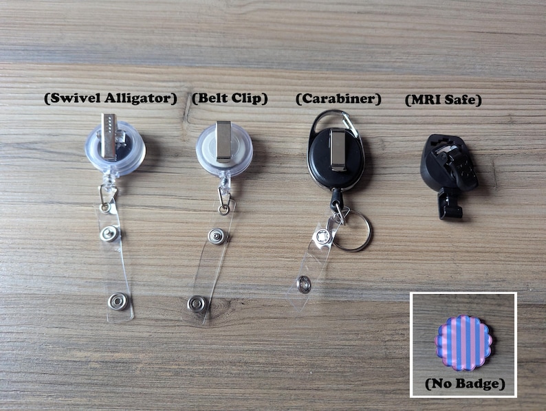 Puede incluir: Se muestran cuatro estilos diferentes de carretes para insignias sobre una superficie de madera. Los estilos incluyen un clip de cocodrilo giratorio, un clip para cintur&oacute;n, un mosquet&oacute;n y un carrete seguro para resonancia magn&eacute;tica. Tambi&eacute;n se muestra una peque&ntilde;a insignia con borde festoneado con rayas azules y rosas, etiquetada como "(No Badge)".
