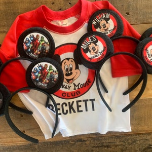 May include: Five black felt Mickey Mouse ears with different character designs. The ears are decorated with images of Mickey Mouse, Avengers characters, and the text "Mickey Mouse Club".