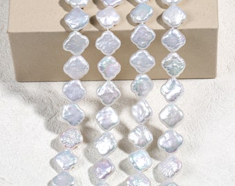 Peut inclure: Un brin de perles d'eau douce blanches en forme de trèfle. Les perles sont enfilées sur un fil blanc et disposées en rangée.