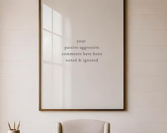 May include: A rectangular framed wall art piece featuring the black text 'your passive-aggressive comments have been noted & ignored' centered on a white background. The frame is a dark wood tone, and the artwork is displayed in a clean, simple style.