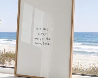 May include: A rectangular framed print with a light wood frame featuring the black text: i'm with you always, you got this. love, Jesus. The print has a white background and is positioned upright, displaying a clear, minimalist design.