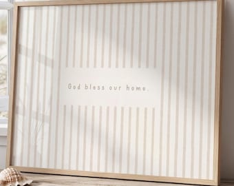 May include: A rectangular wall art print in a light wood frame featuring a vertical beige and white striped pattern. The center of the print contains the text "God bless our home." in a simple, dark brown sans-serif font on a solid background.