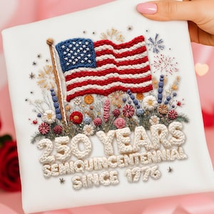 May include: A white square textile with an embroidered American flag, surrounded by flowers and fireworks. The text "250 YEARS SEMIQUINCENTENNIAL SINCE 1776" is also embroidered on the textile.
