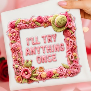 Könnte beinhalten: Ein weißes Quadrat mit einem rosa gehäkelten Rahmen, verziert mit Blumen, Blättern und einem kleinen Hut. Der Text "I'LL TRY ANYTHING ONCE" ist in rosa Häkelschrift. Ein kleiner grüner Frosch ist ebenfalls enthalten.