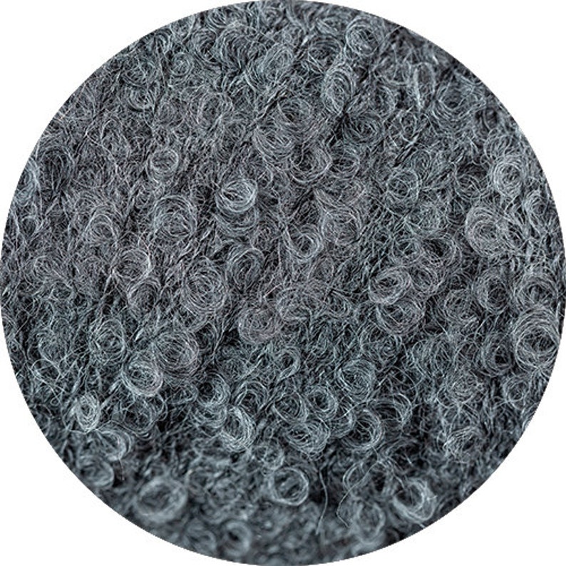 May include: Close-up of a dark gray yarn with a fuzzy texture. The yarn is made of wool and is perfect for knitting or crocheting.