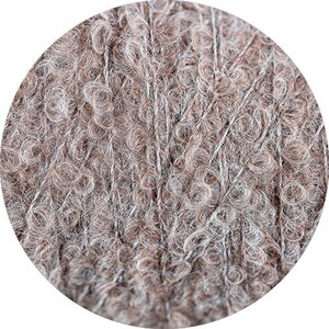 May include: Close-up of a skein of brown and white yarn with a fuzzy texture.