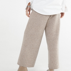 May include: Beige wide-leg pants with a speckled texture. The pants are made of a soft, comfortable fabric and have a relaxed fit.
