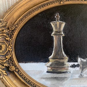 May include: An oil painting in an ornate oval gold frame depicting a vertical chess king piece standing on a white surface against a black background, with a second chess piece lying horizontally on its side next to the upright king piece.
