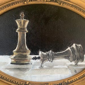 May include: An oil painting in an oval gold frame depicting a standing gold chess king piece next to a fallen silver chess king piece on a white and gray checkered surface against a solid black background, with a small signature in the corner.