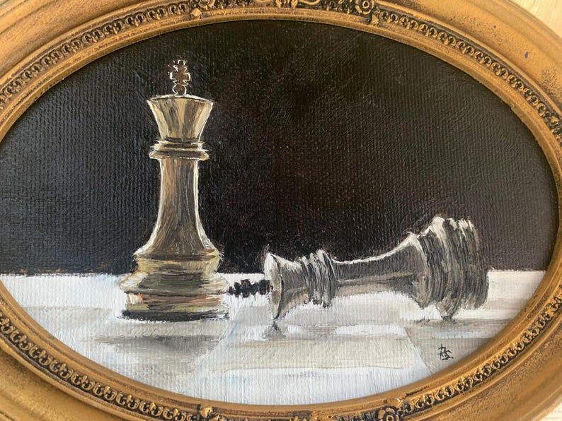 May include: An oil painting in an oval gold frame depicting a standing gold chess king piece next to a fallen silver chess king piece on a white and gray checkered surface against a solid black background, with a small signature in the corner.