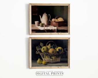 May include: Two framed still life paintings. The top painting shows a white teapot, a glass, a green apple, and a basket of bread on a wooden table with a white cloth. The bottom painting shows a basket of yellow pears with green leaves on a dark background.