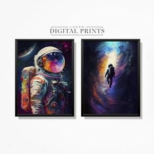 Puede incluir: Dos impresiones digitales enmarcadas de astronautas en el espacio. La primera impresión presenta a un astronauta con un traje espacial colorido con una galaxia reflejada en el casco. La segunda impresión muestra a un astronauta flotando a través de una nebulosa arremolinada.