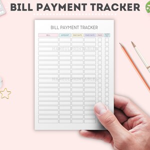 May include: A white bill payment tracker with pastel-colored headers, held by a hand. The tracker includes columns for bill, amount, due date, paid date, and auto-pay. The text "BILL PAYMENT TRACKER" is at the top.