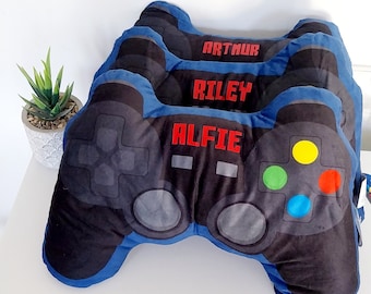 May include: Three blue and black gaming controller pillows with the names Arthur, Riley, and Alfie embroidered in red on them.