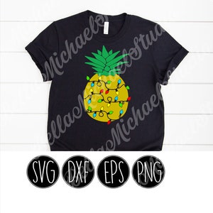 Op de afbeelding: Een zwart T-shirt met een gele ananas met kleurrijke kerstverlichting eromheen. De tekst "SVG DXF EPS PNG" staat onder de afbeelding.