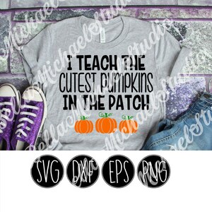 Peut inclure: Un t-shirt gris avec le texte "I teach the cutest pumpkins in the patch" en noir. Trois citrouilles orange avec des tiges vertes sont sous le texte. Le t-shirt est sur un fond de briques.