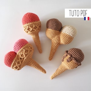 Könnte beinhalten: Vier gehäkelte Eiswaffeln in verschiedenen Farben. Die Waffeln sind aus braunem Garn und das Eis aus rosa, weißem und braunem Garn. Die Eiswaffeln sind in einem Kreis auf weißem Hintergrund angeordnet. Tuto PDF.
