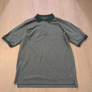 May include: Green and gray striped polo shirt with short sleeves. The shirt has a dark green collar and sleeve cuffs. The shirt is made of a soft, breathable fabric.
