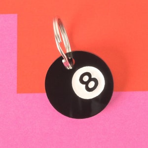 May include: Black and white 8-ball keychain with a silver key ring.