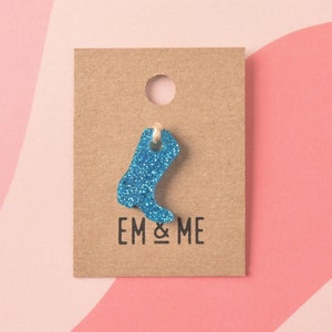 May include: A blue glitter cowboy boot charm with a brown tag that says "EM & ME".